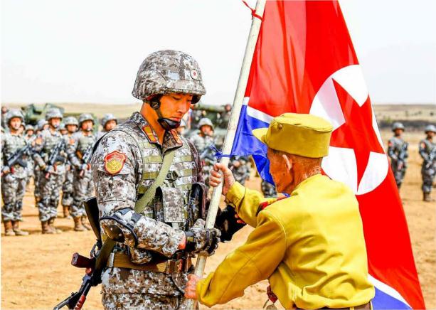 A war veteran is handing a national flag over to the new generation of soldiers