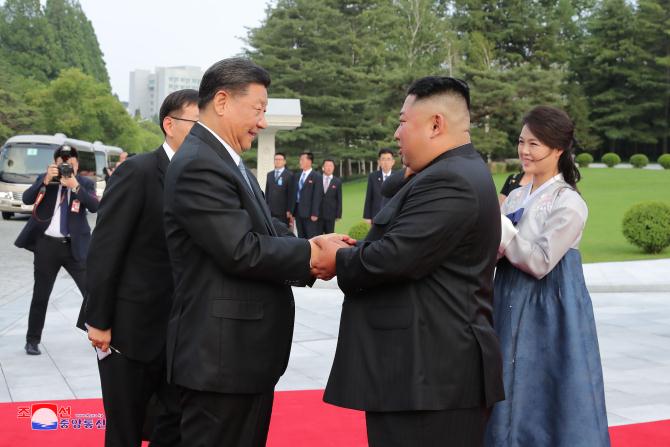 경애하는 최고령도자 김정은동지께서와 습근평동지께서 조선로동당 중앙위원회 본부청사에서 당중앙위원회 정치국 성원들과 함께 기념촬영을 하시였다