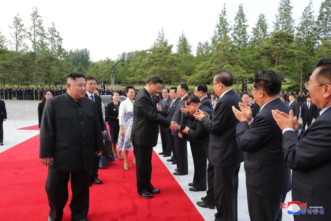 경애하는 최고령도자 김정은동지께서와 습근평동지께서 조선로동당 중앙위원회 본부청사에서 당중앙위원회 정치국 성원들과 함께 기념촬영을 하시였다