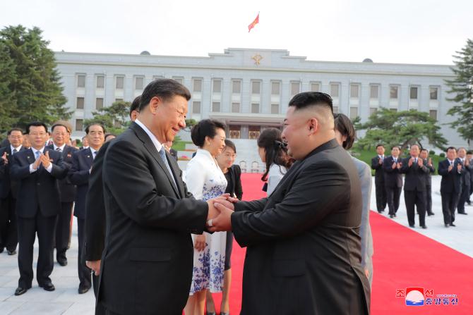 경애하는 최고령도자 김정은동지께서와 습근평동지께서 조선로동당 중앙위원회 본부청사에서 당중앙위원회 정치국 성원들과 함께 기념촬영을 하시였다